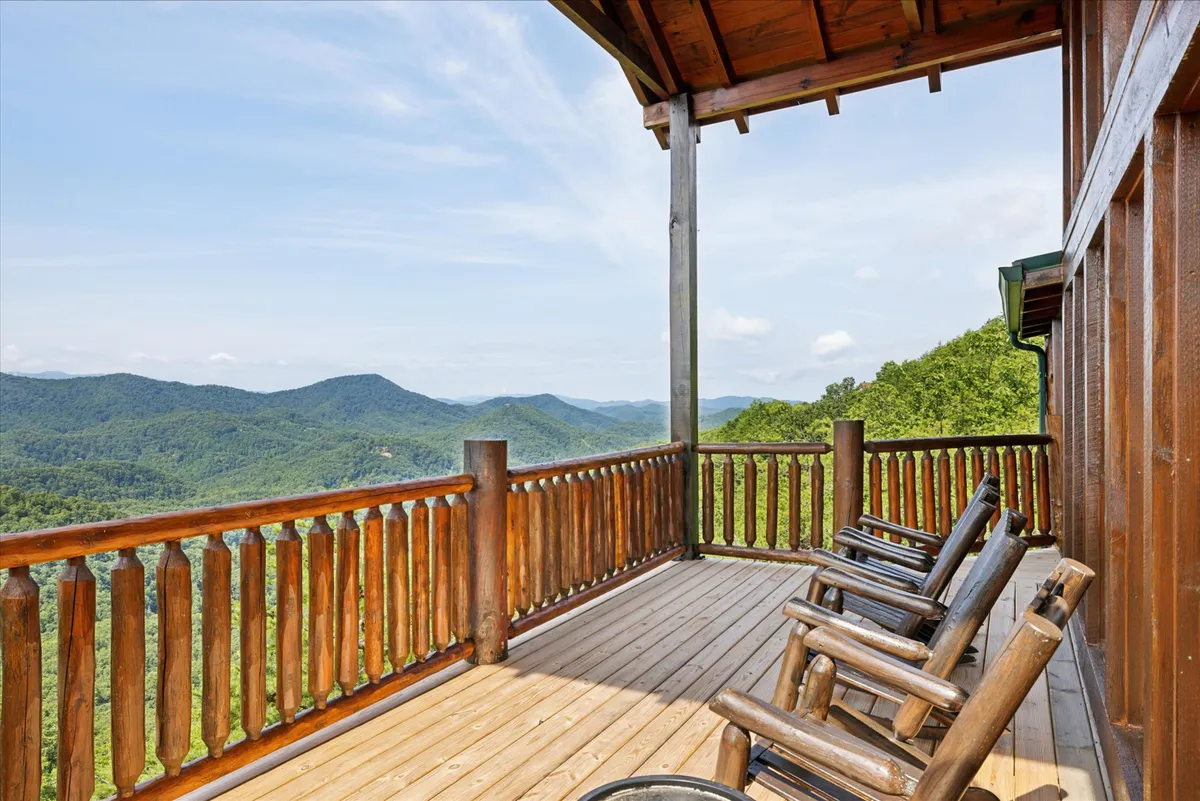 A peaceful porch scene with wooden railings, rocking chairs, and sweeping mountain views. The setting invites guests to unwind, socialize, and take in the natural beauty around them.