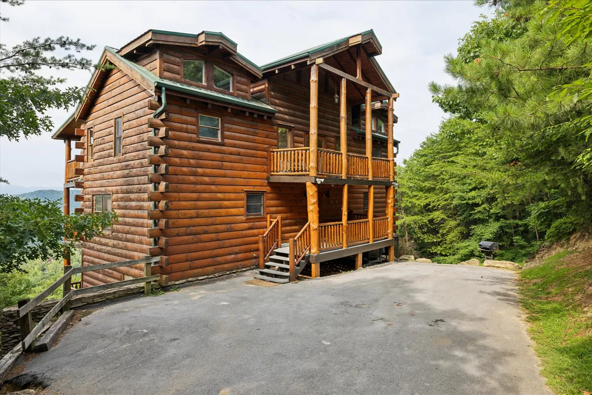 A log cabin nestled amid lush greenery, featuring a classic porch with railings that invite relaxation and gatherings. The surrounding landscape emphasizes privacy and connection to preserved nature.